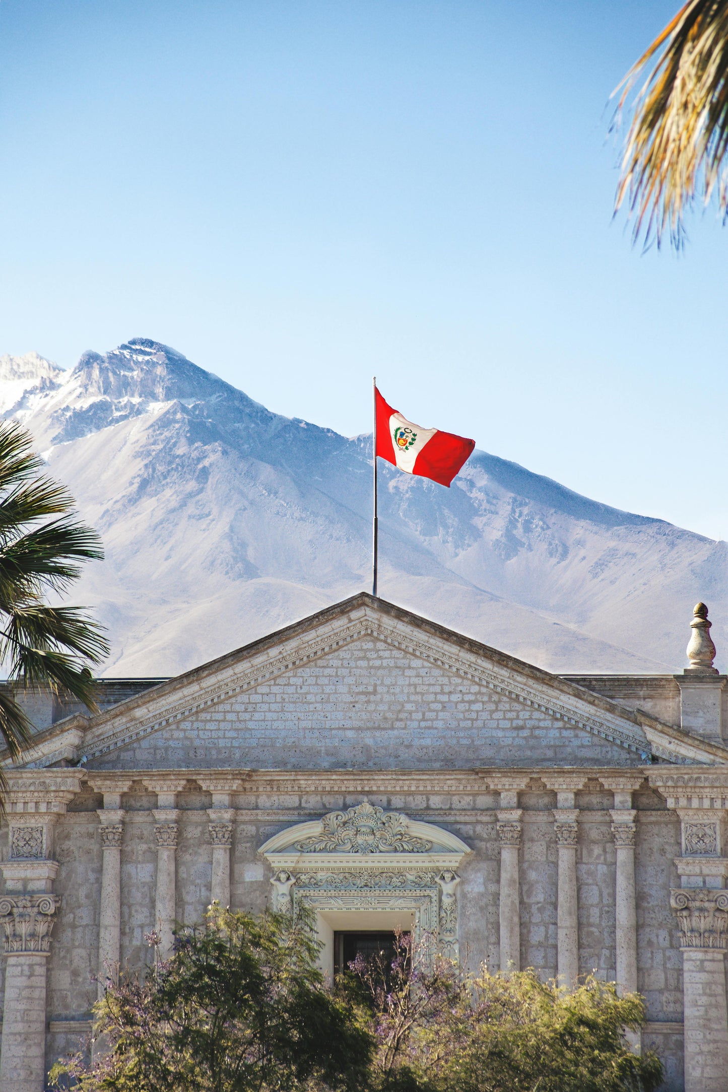 Building with a flag against a mountainous background
