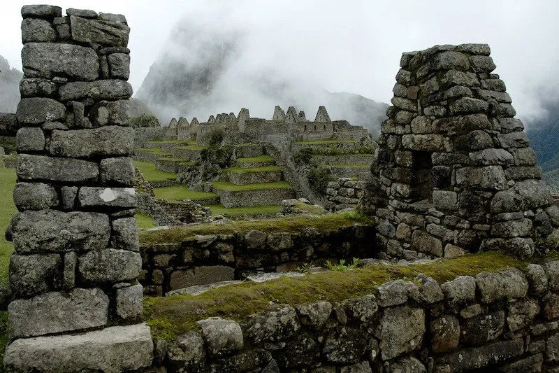 Stone ruins of an ancient civilization with misty mountains in the background