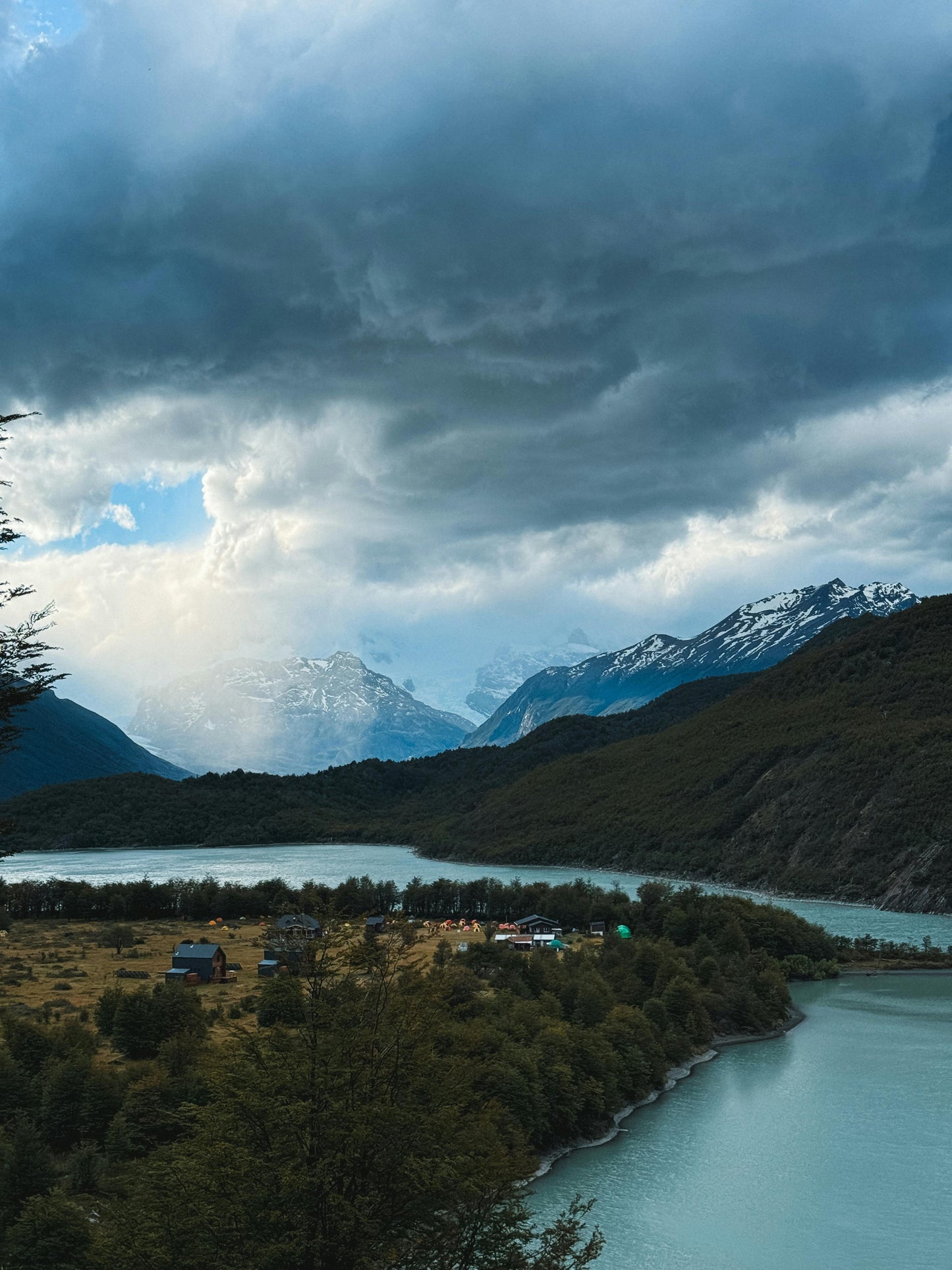 Scenic view of a lake with mountains under a cloudy sky