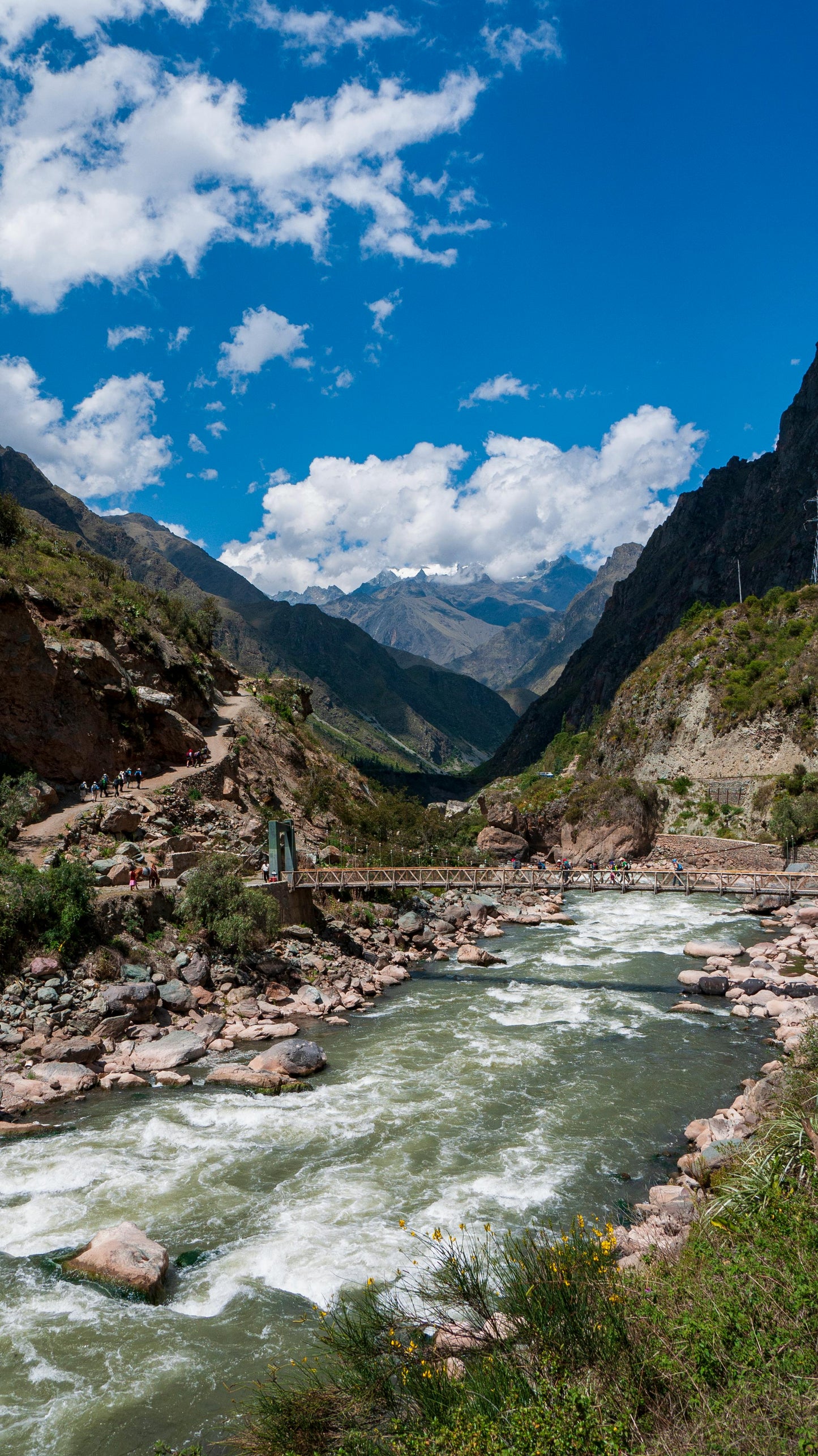 River flowing through a mountainous landscape with a bridge.