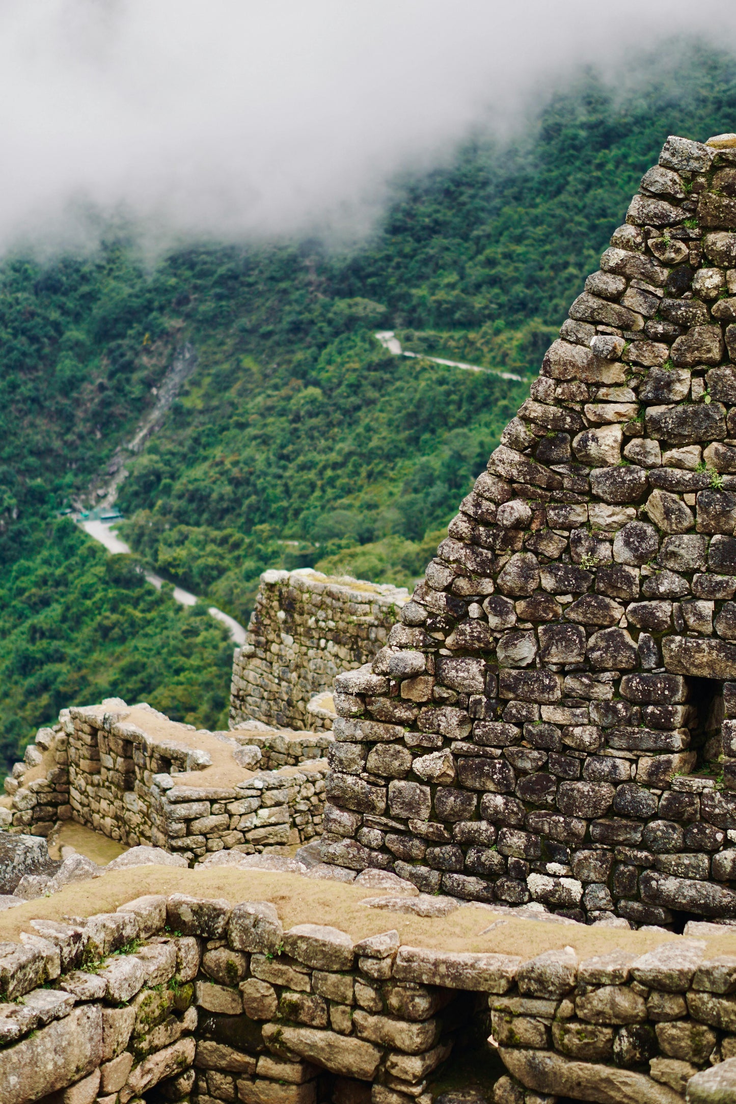 Stone ruins of Machu Picchu with misty mountains in the background