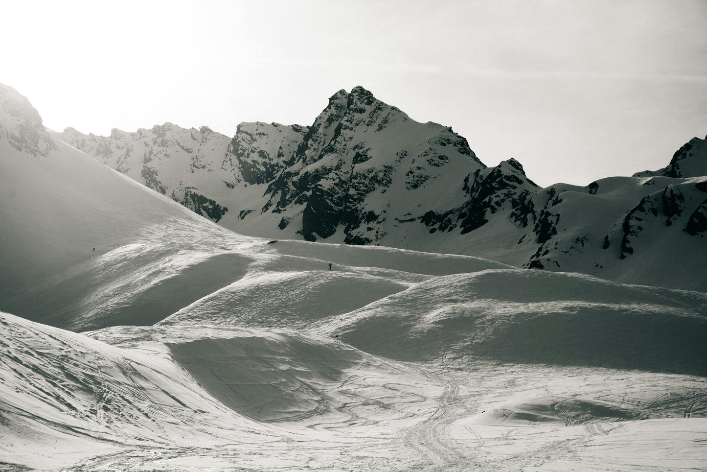 Snowy mountain landscape with a prominent peak under a cloudy sky