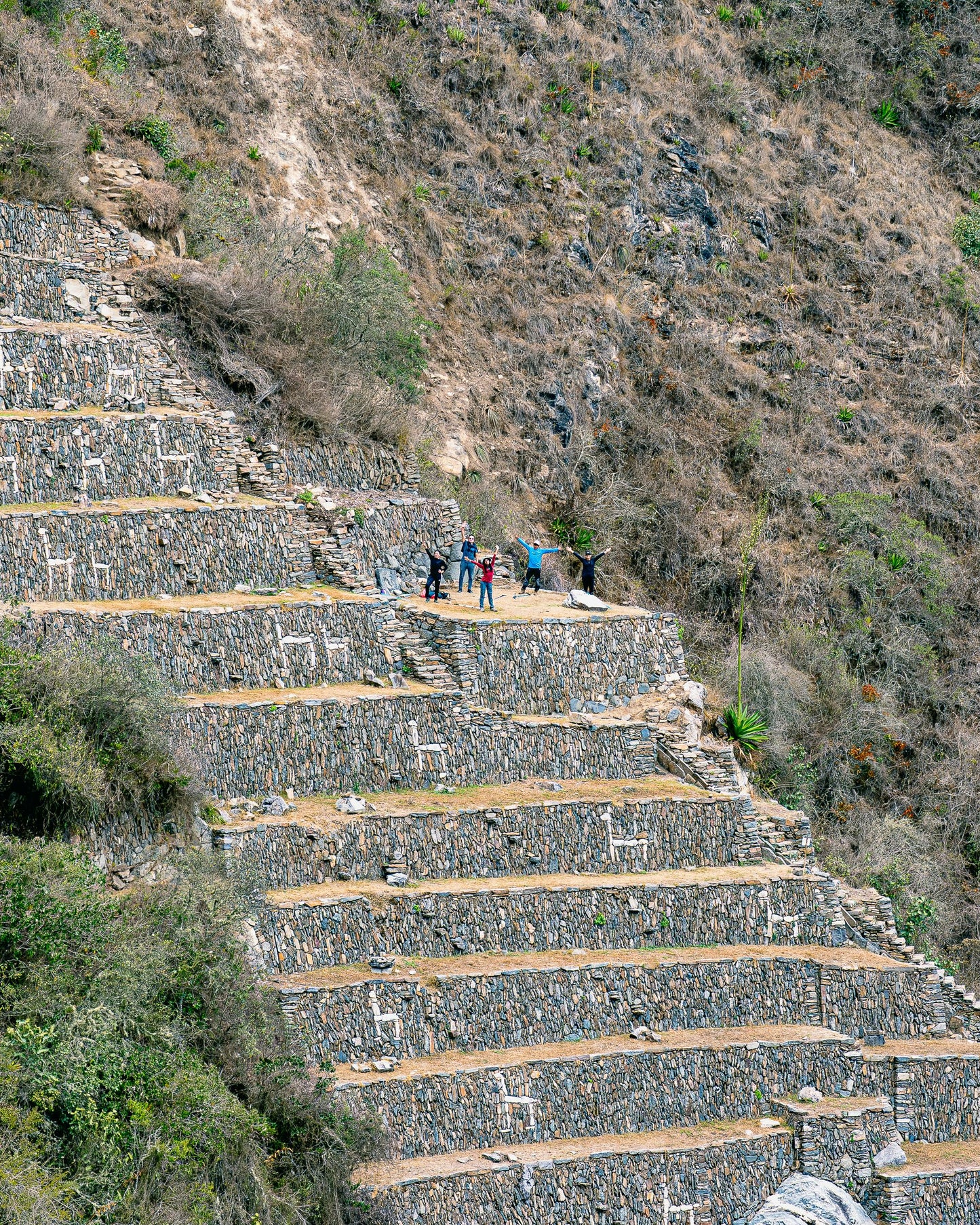 Staircase made of stone steps leading up a mountain with people at the top.