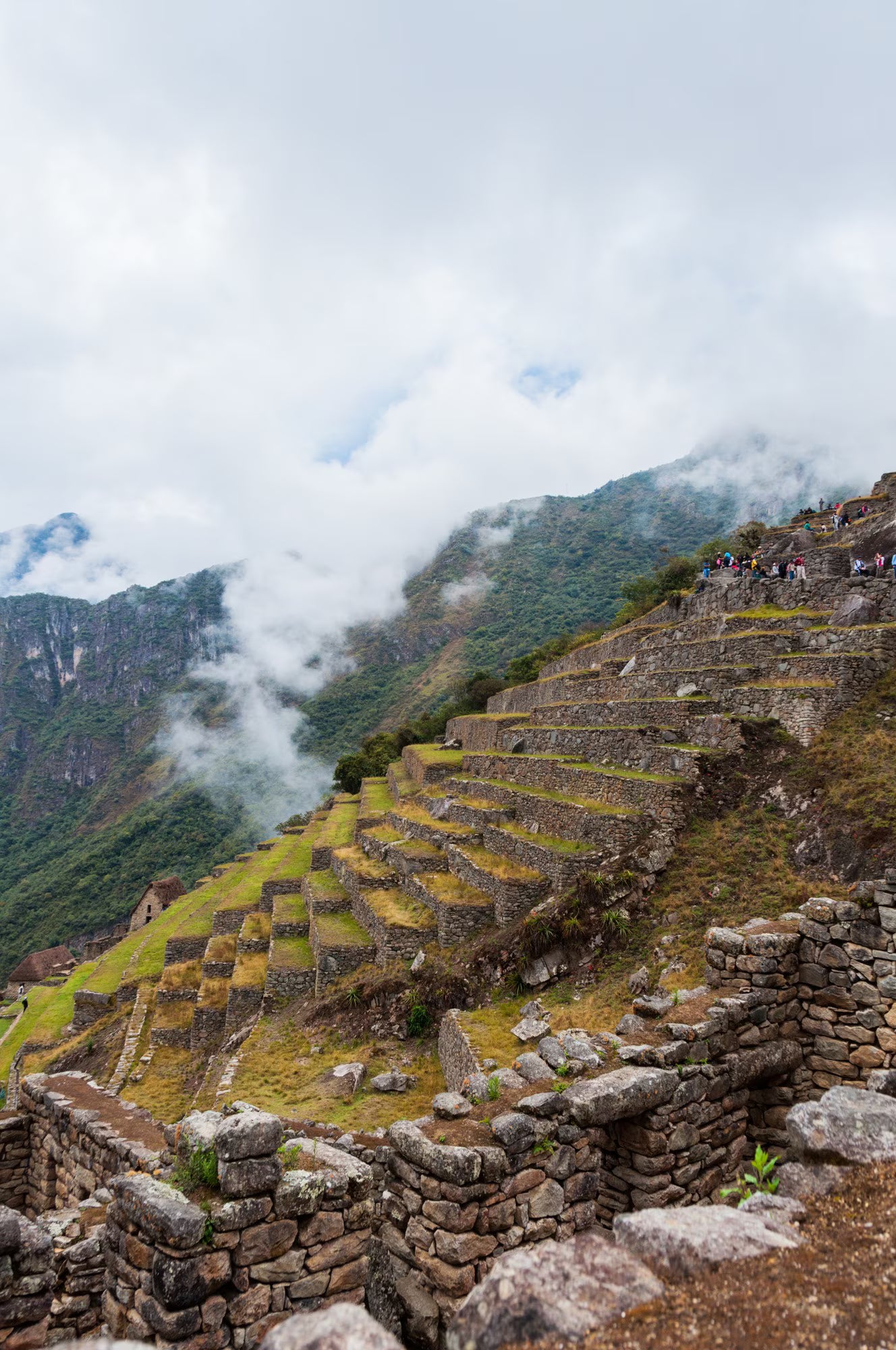 Stone ruins of Machu Picchu with misty mountains in the background