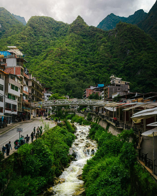 Town nestled in a valley with a river and mountains