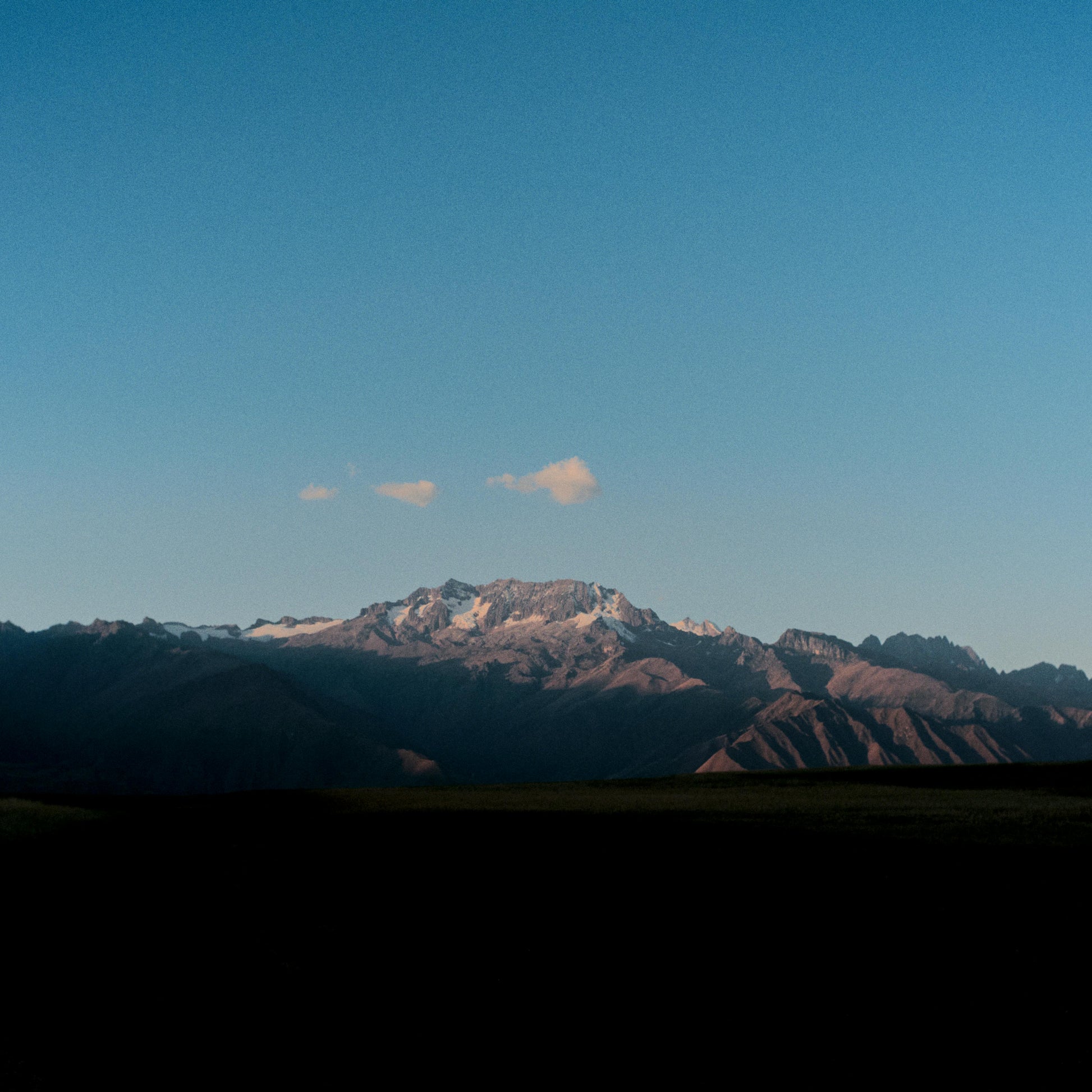 Mountain range with snow-capped peaks under a clear blue sky