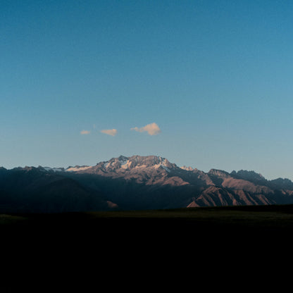 Mountain range with snow-capped peaks under a clear blue sky