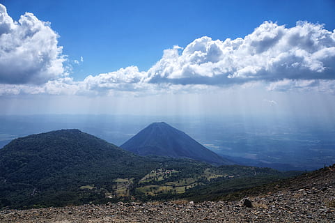 Scenic view of mountains with clouds under a blue sky
