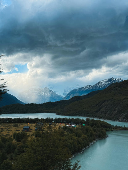 Scenic view of a lake with mountains under a cloudy sky