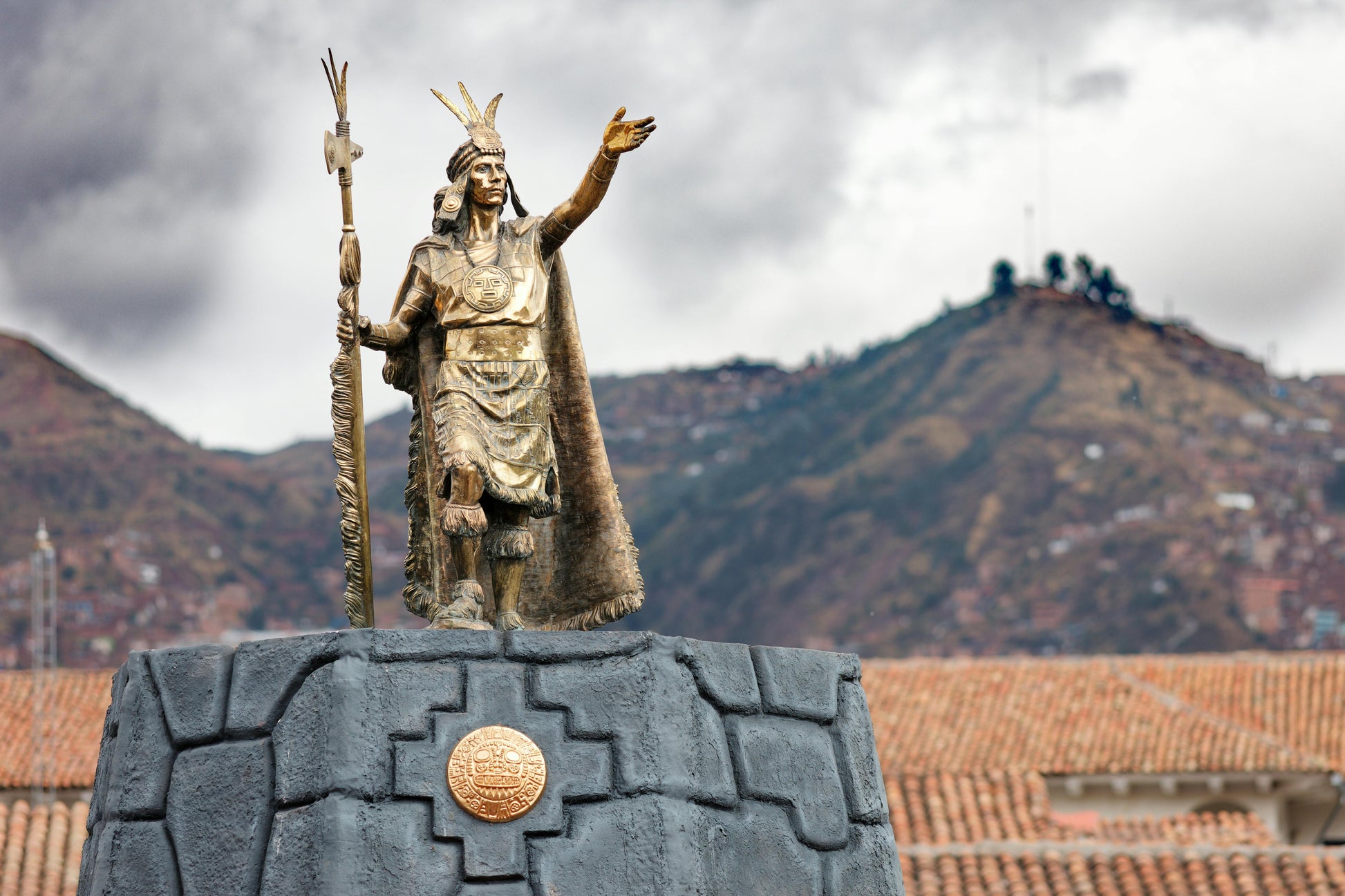 Statue of a historical figure with mountains in the background