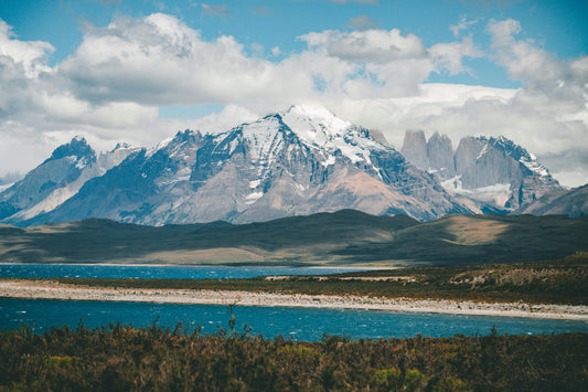 Scenic view of mountains with snow and a lake in the foreground