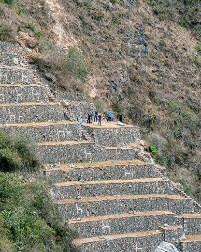 Staircase made of stone steps leading up a mountain with people at the top.